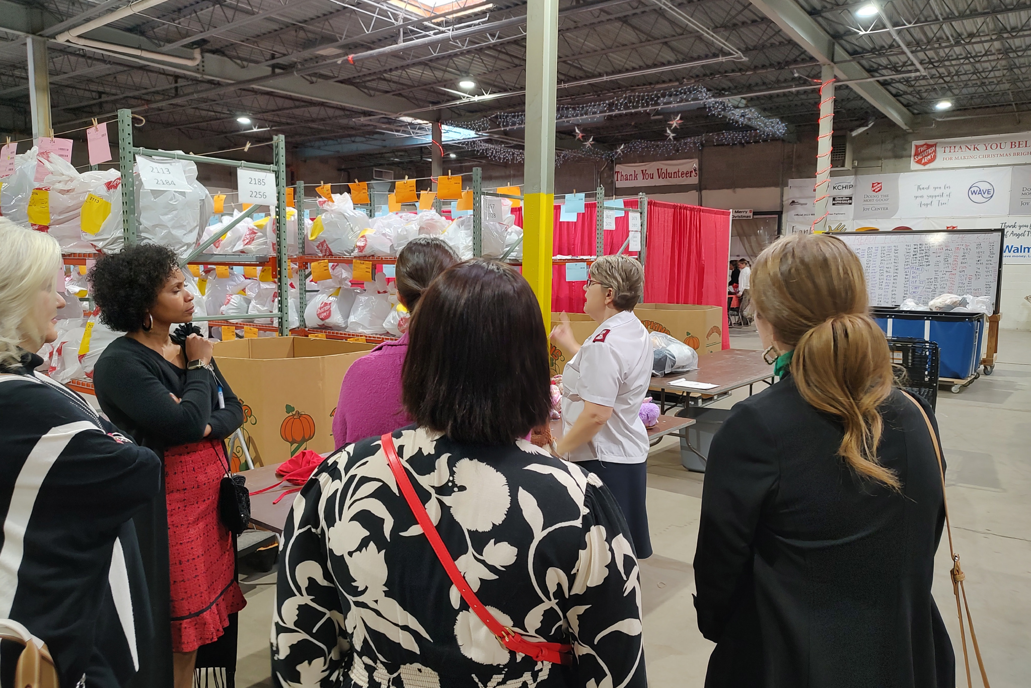 Angel Tree group meeting near aisles of gift bags
