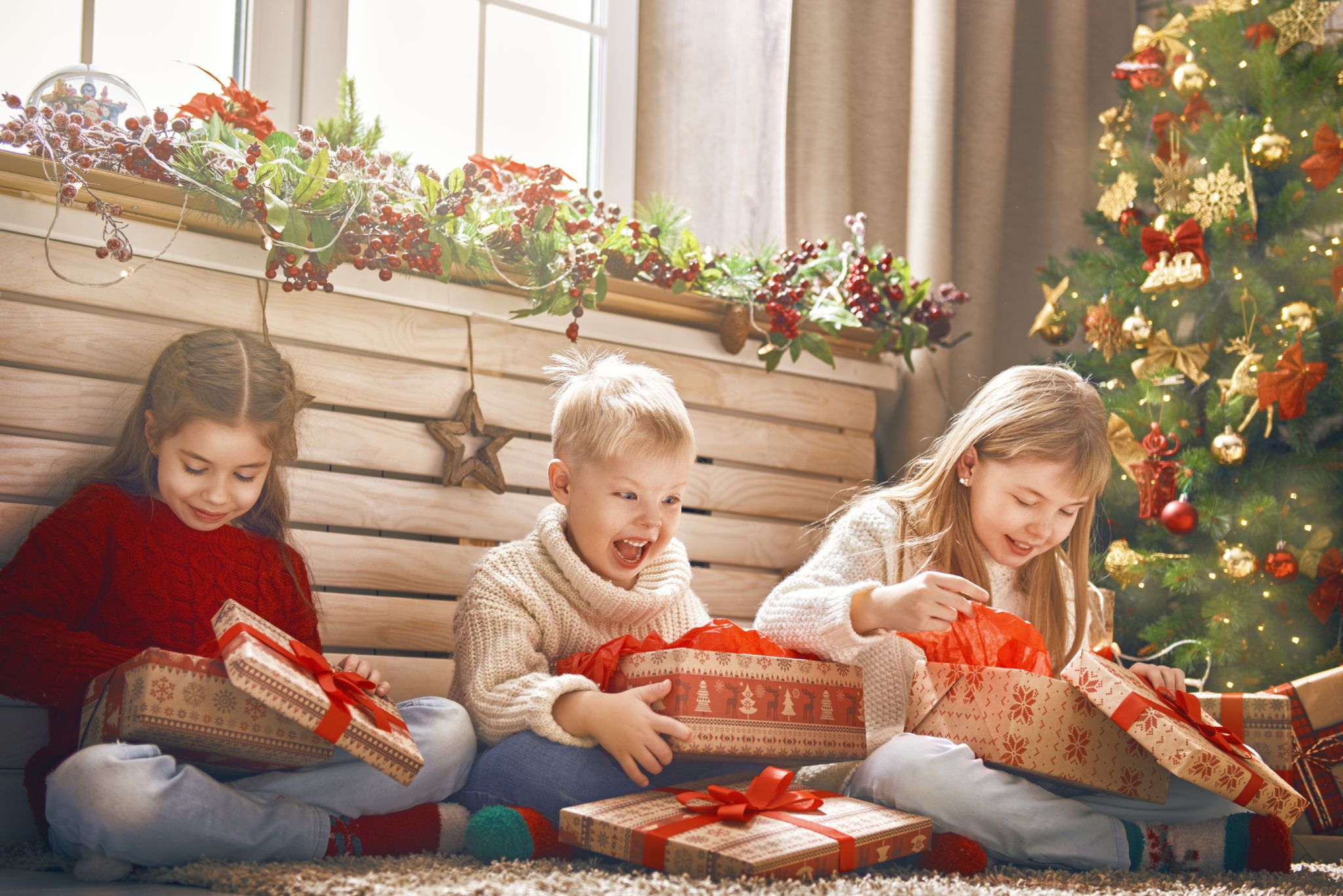 Children with their presents by the Christmas tree