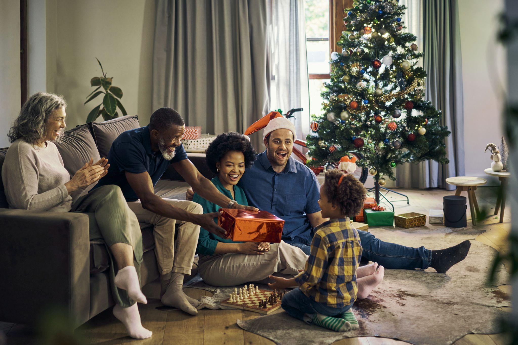 Family handing gift to child at Christmas